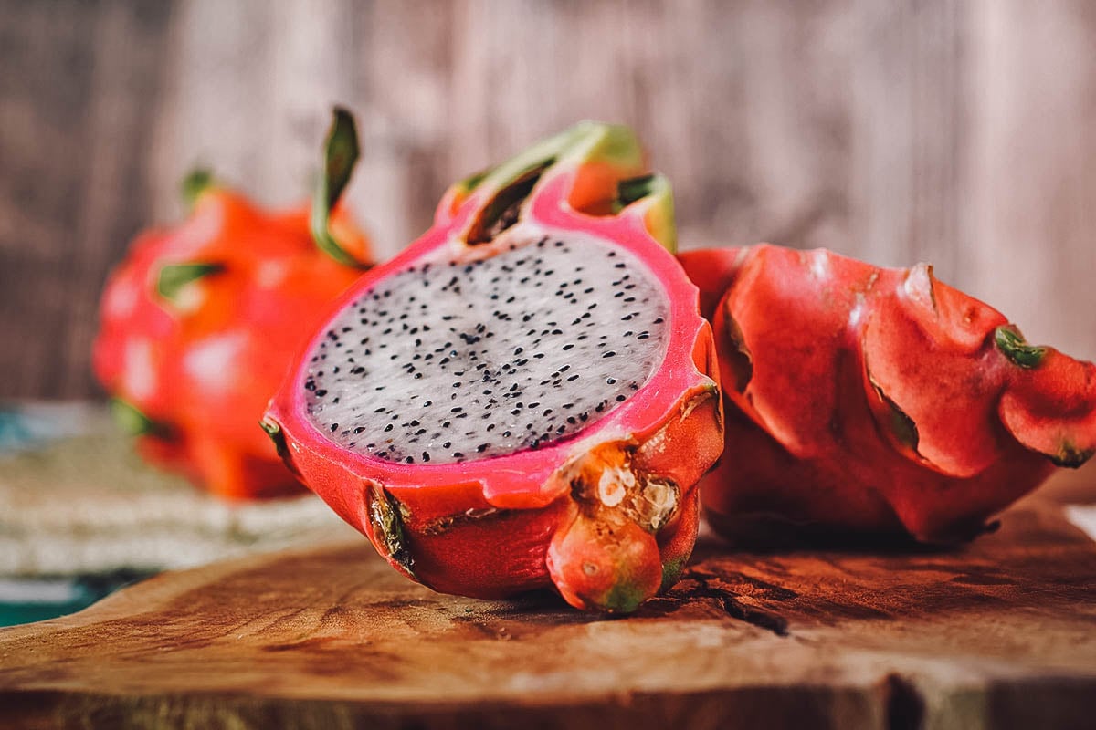 Sliced dragon fruit with white fruit and many small black seeds