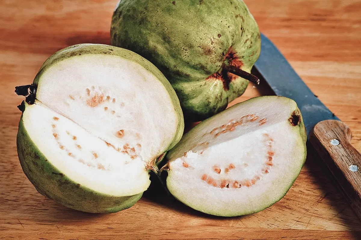 Guava sliced open showing the white fruit and many seeds