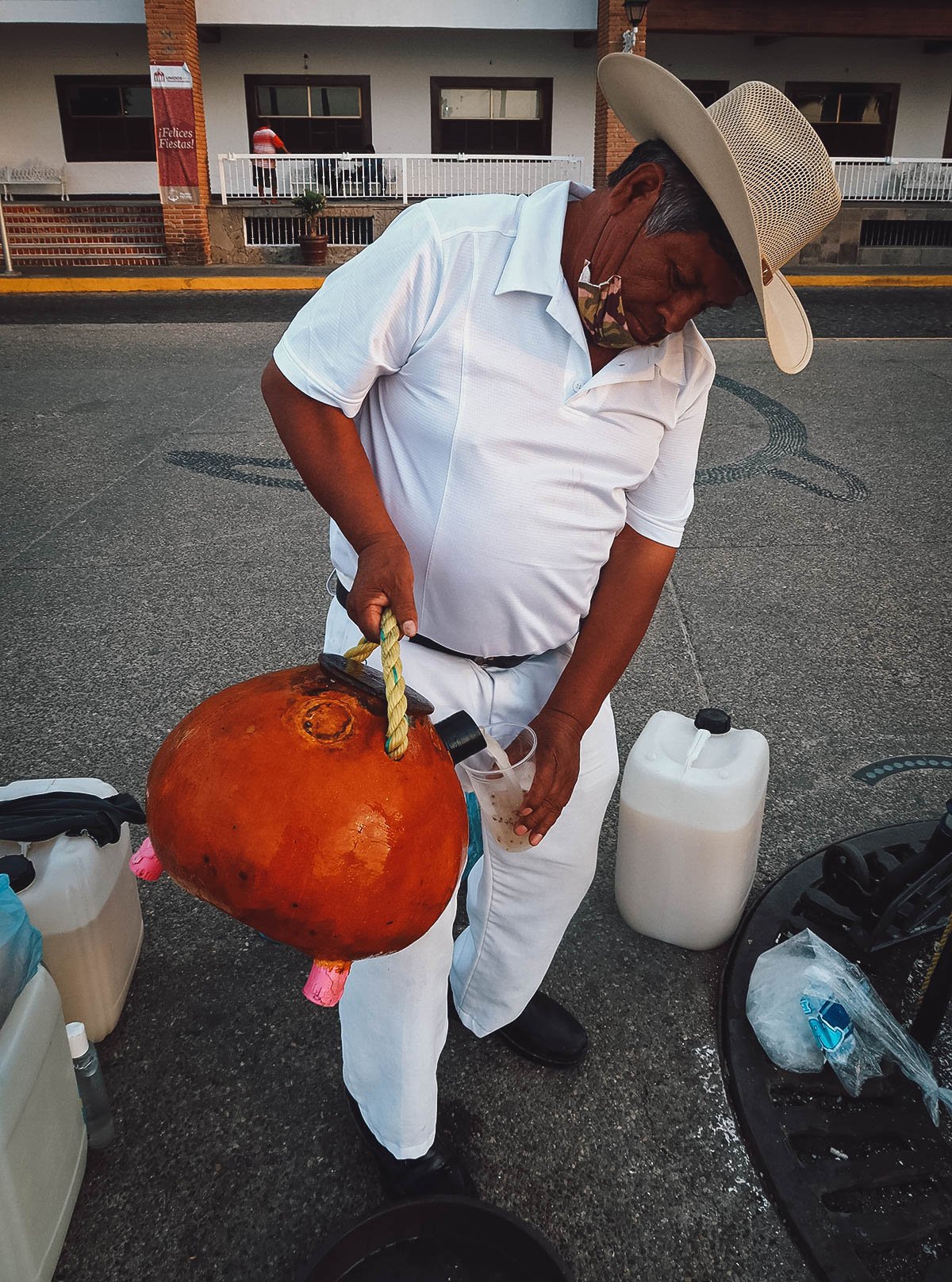 Vendor pouring a glass of tuba in Puerto Vallarta