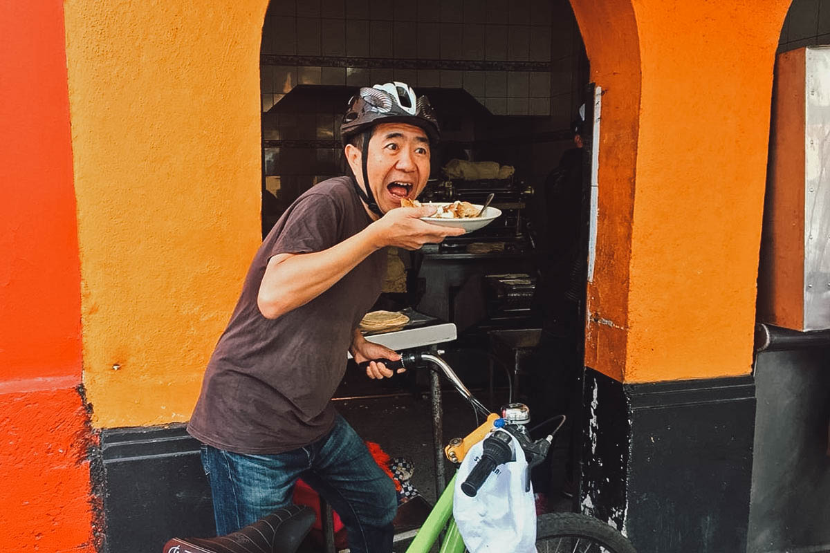Mexico City Food Tours Biking food tour participant with a plate of Mexican food