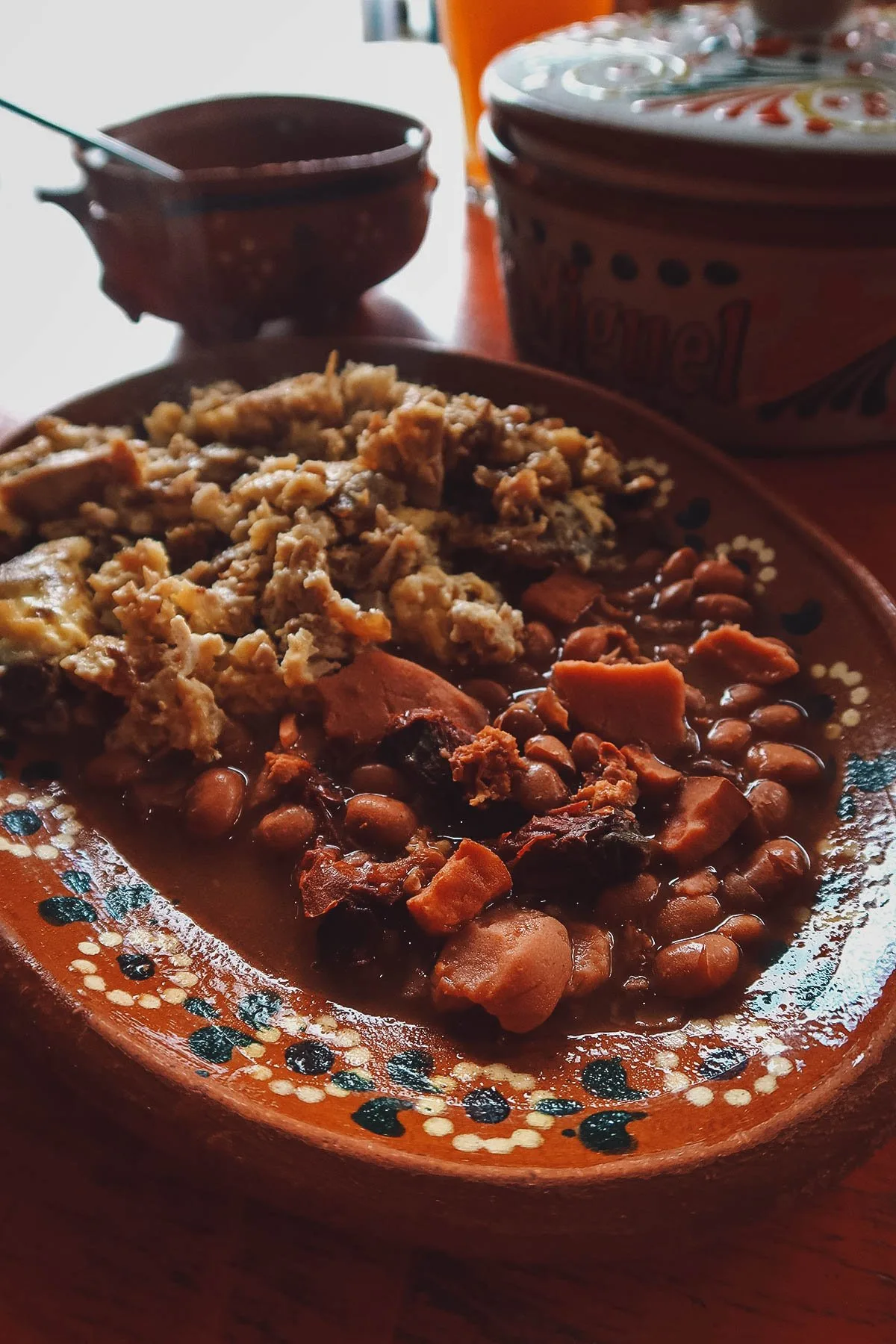 Scrambled eggs with carnitas, ham, and beans