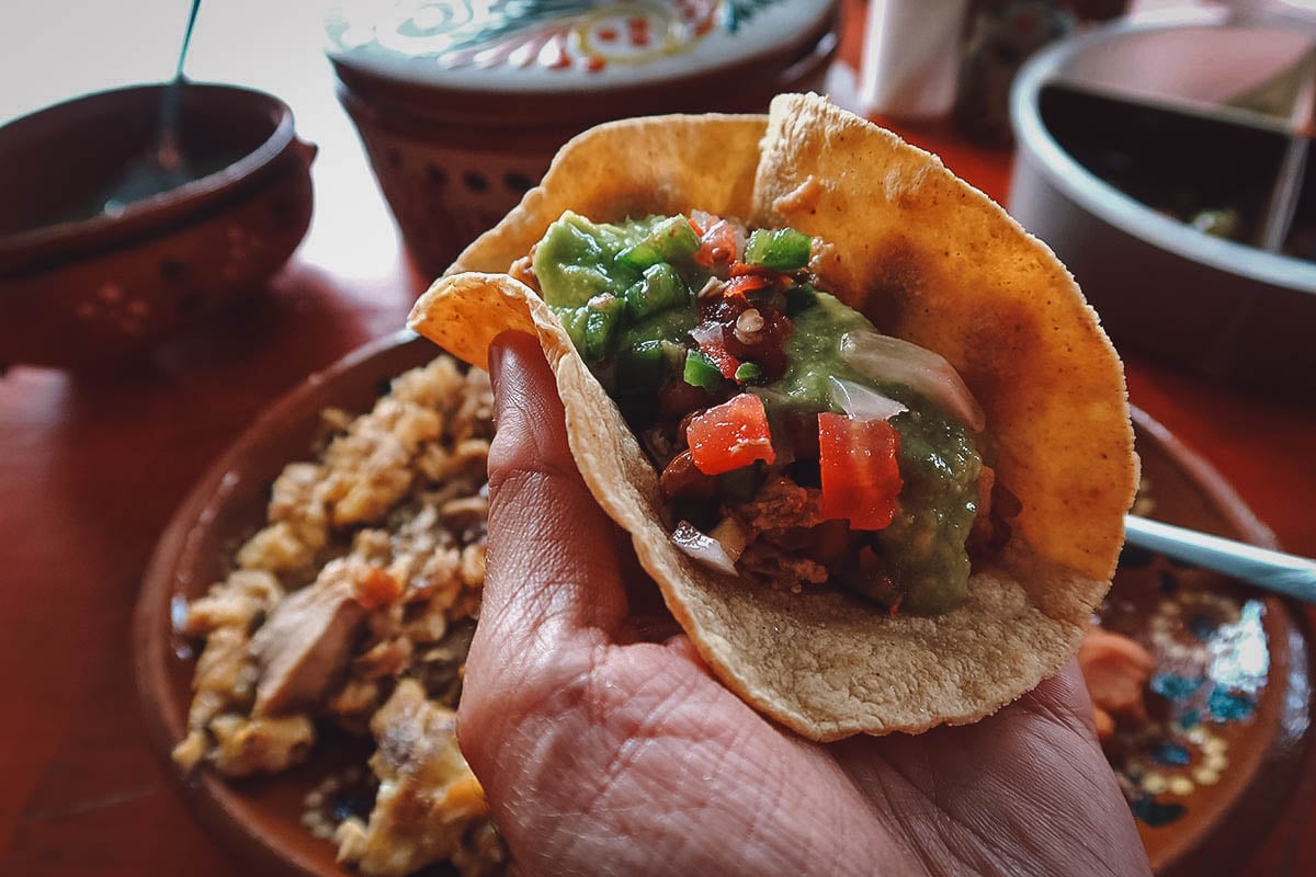 Huevos revueltos con carnitas in a corn tortilla with salsa verde