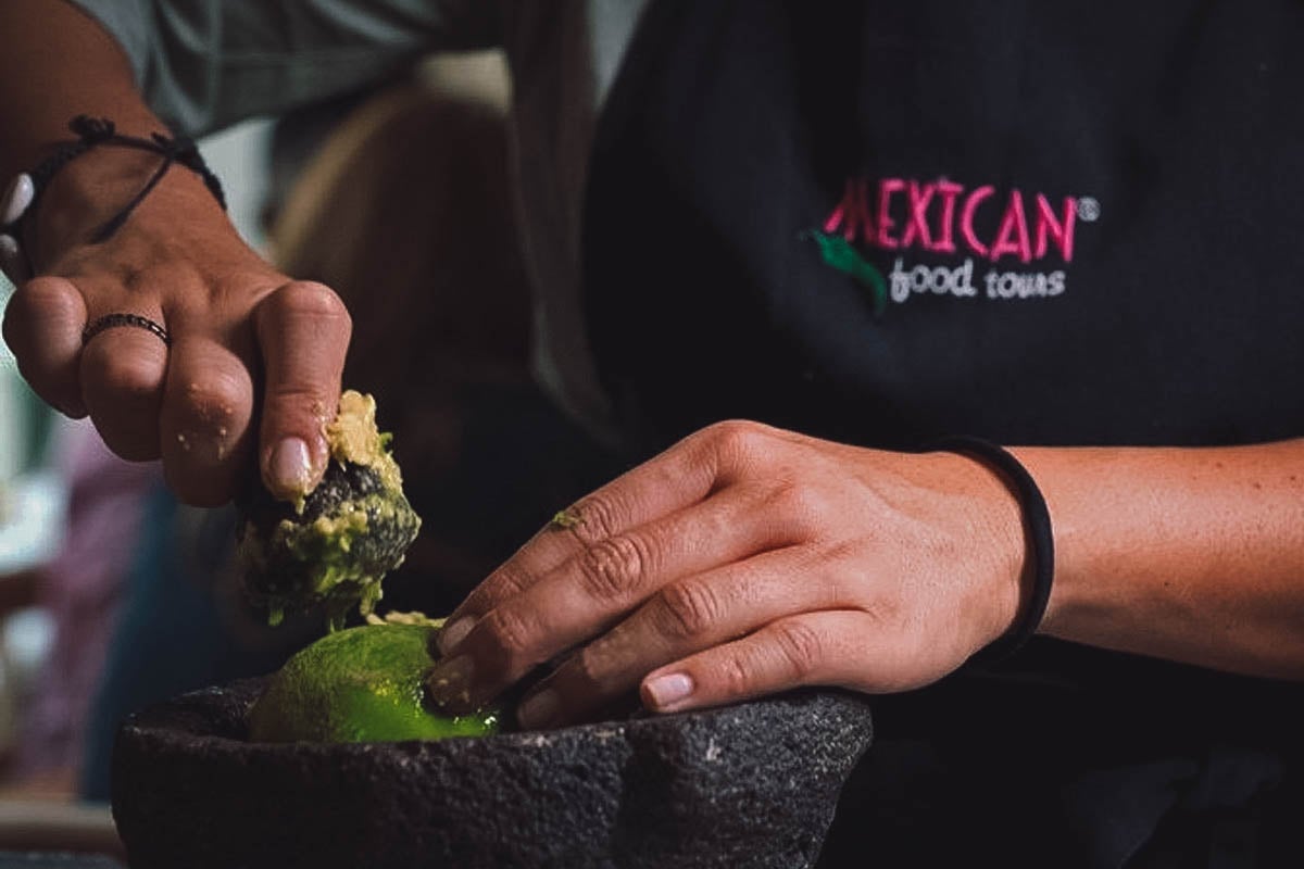 Chef grinding ingredients in a molcajete