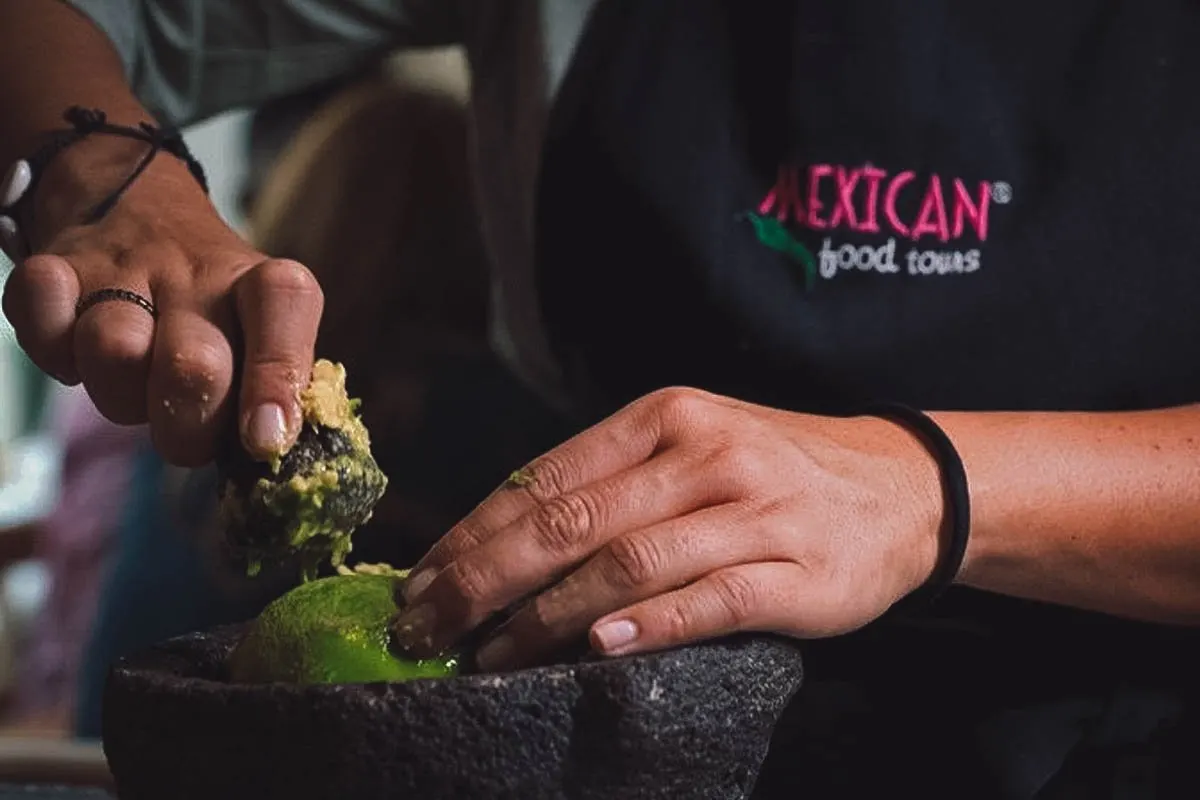 Chef grinding ingredients in a molcajete