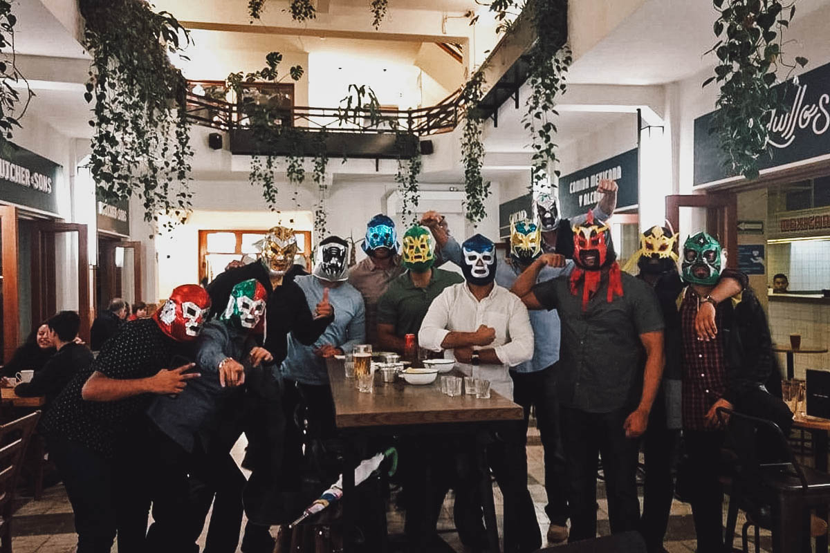Tourists wearing luchador masks at a mezcal bar