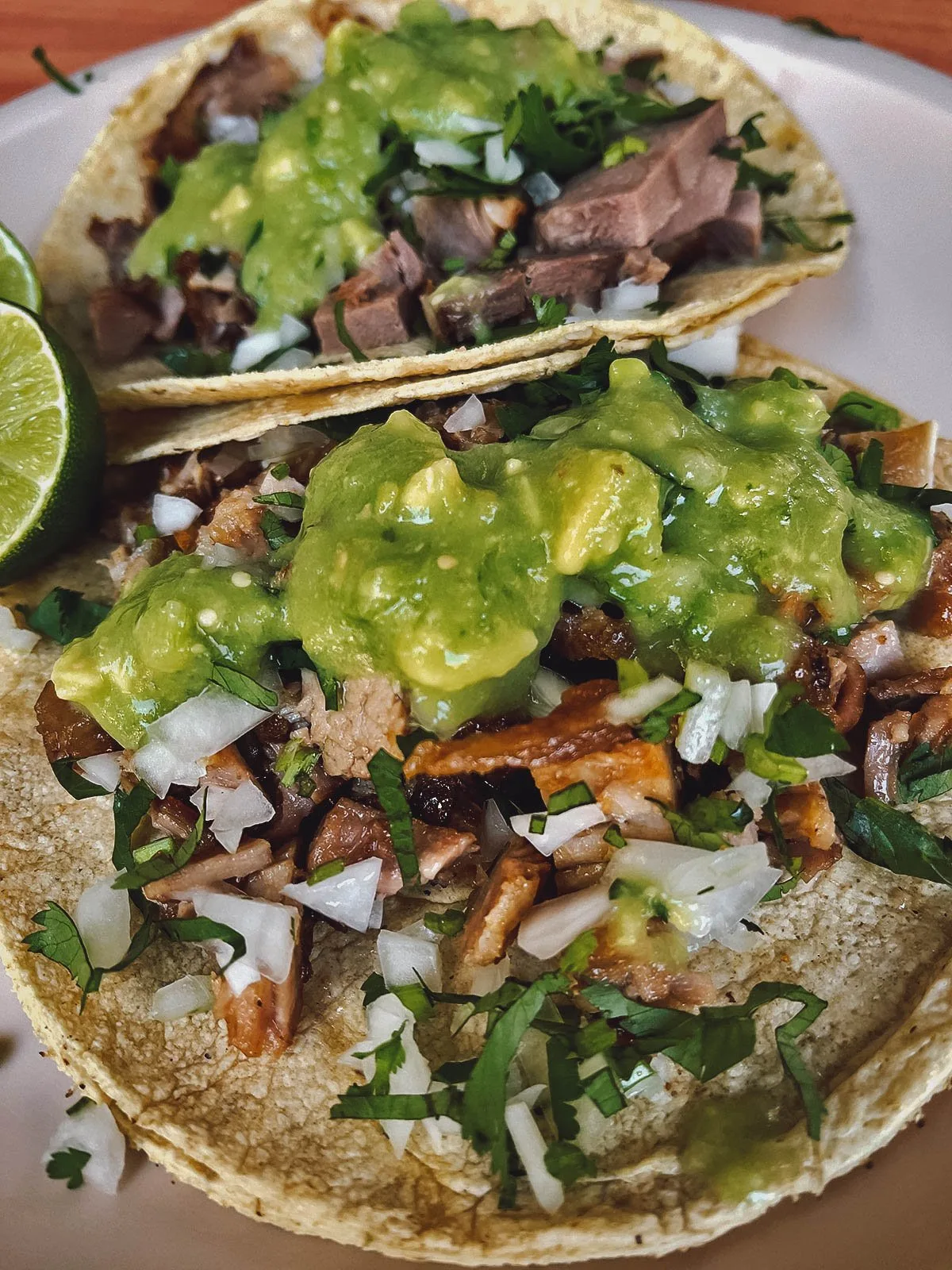 Carnitas topped with guacamole and salsa verde cruda