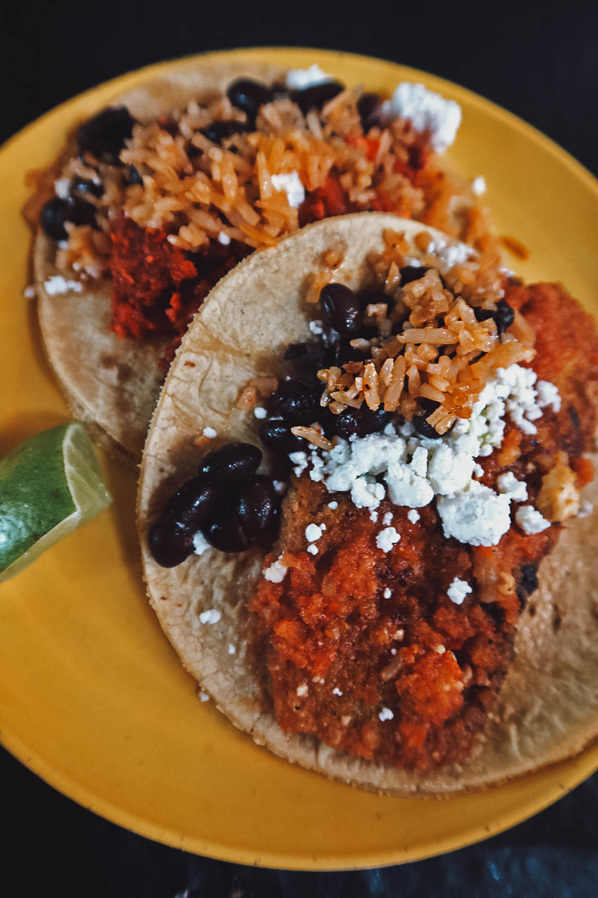 Tacos de guisado with rice, fried beans, and queso fresco