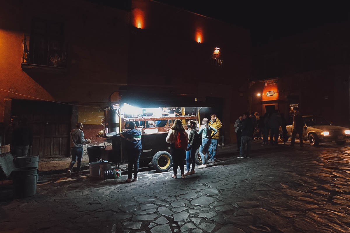Customers gathered around a late night taco stand