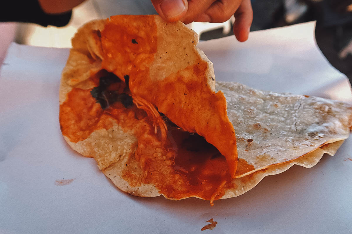 Yellow mole sauce inside an empanada de amarillo