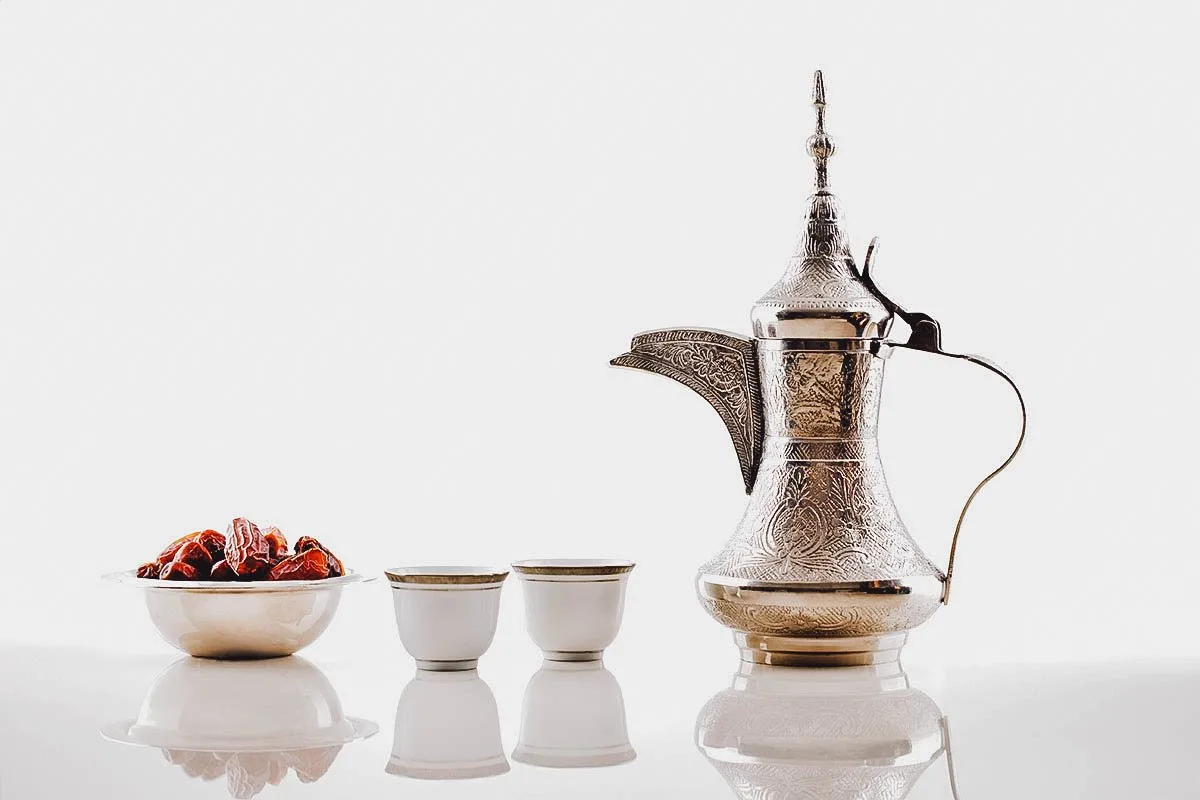 Dallah or coffee pot with Arabic coffee and a bowl of dates