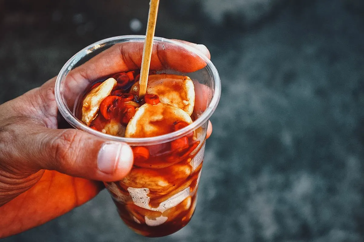 Plastic cup of fish balls with a spicy sauce