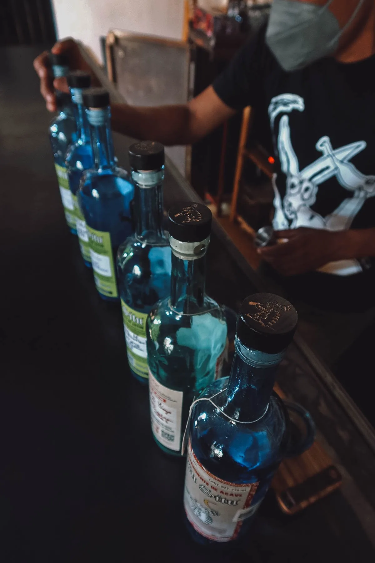 Six blue bottles at a mezcaleria