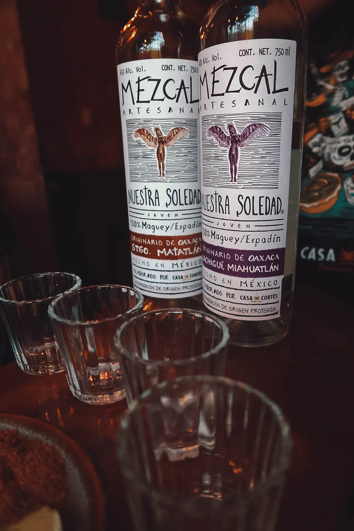 The Best Mezcalerias in Oaxaca Bottles and glasses at Mezcalogia