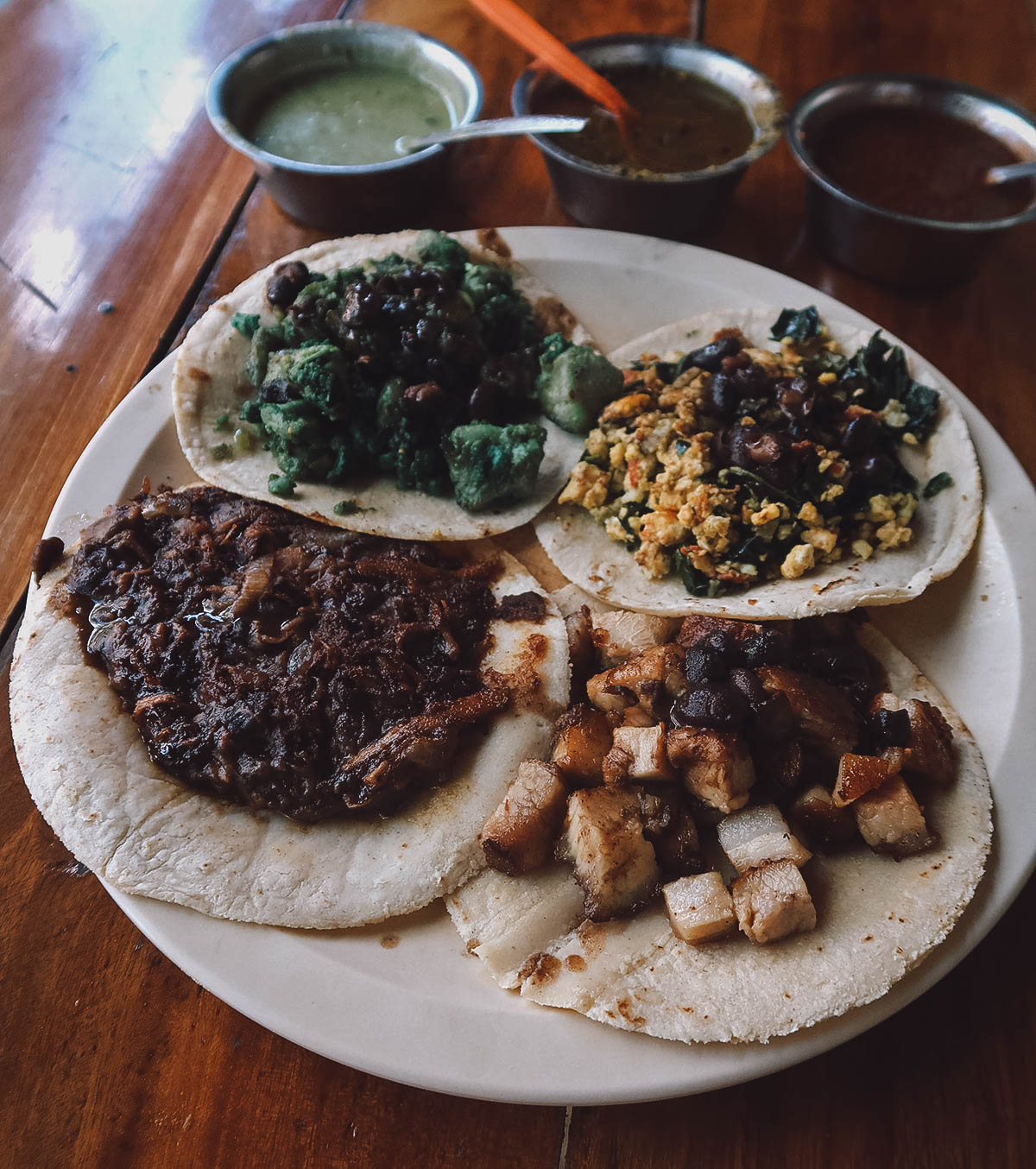 Fried egg with chaya, green chicken, chilibull, and pork belly tacos