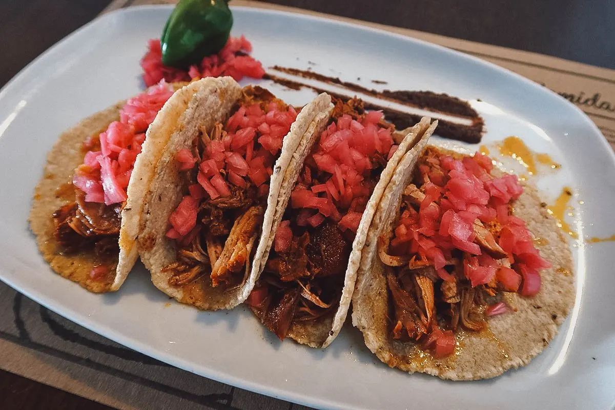 Cochinita pibil tacos topped with pickled red onions