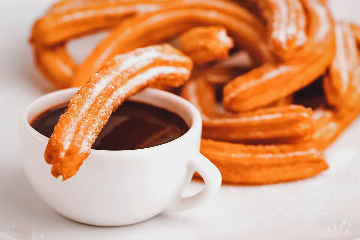 Types of Donuts From Around the World Churros with a cup of hot chocolate
