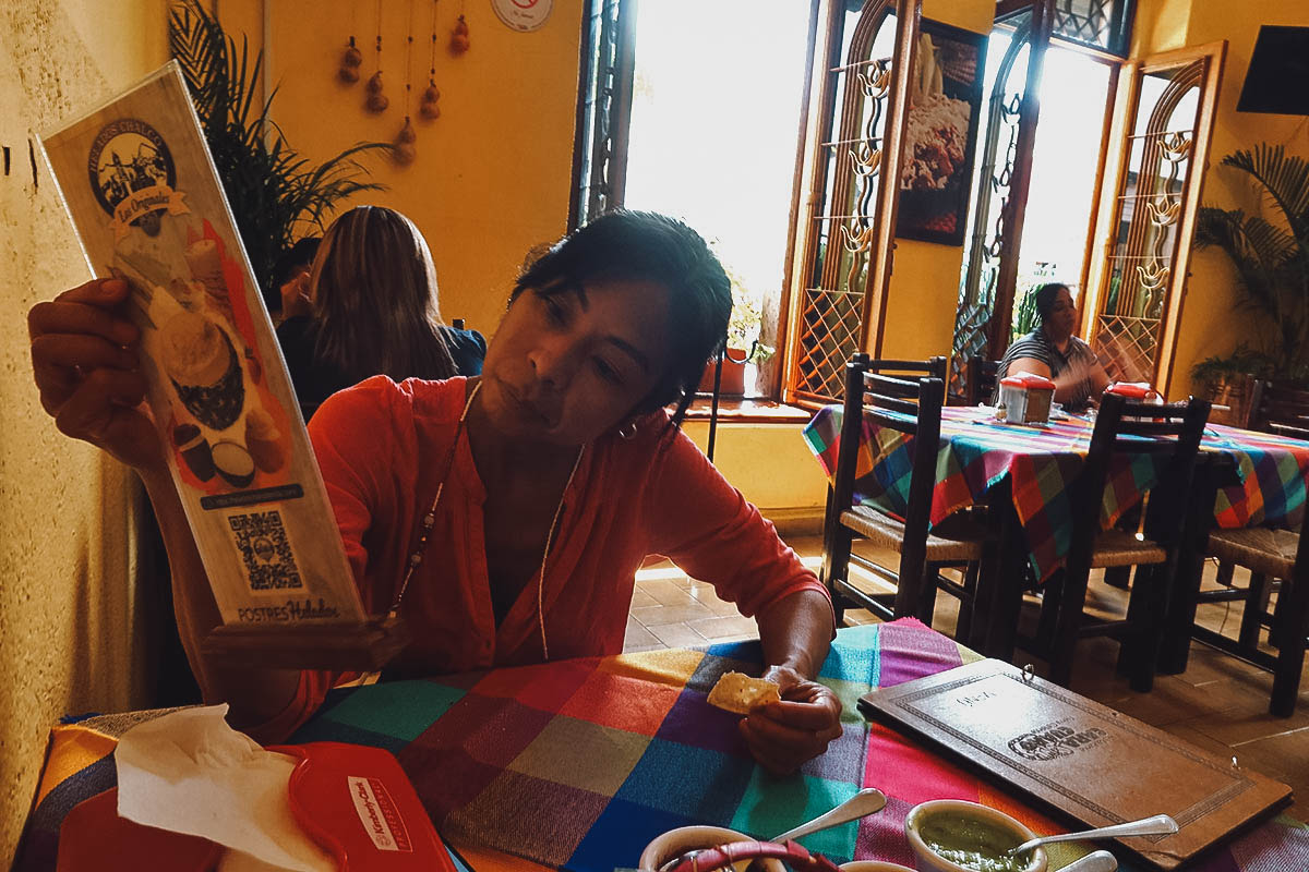 Ren looking at a menu inside Restaurante Caracuaro