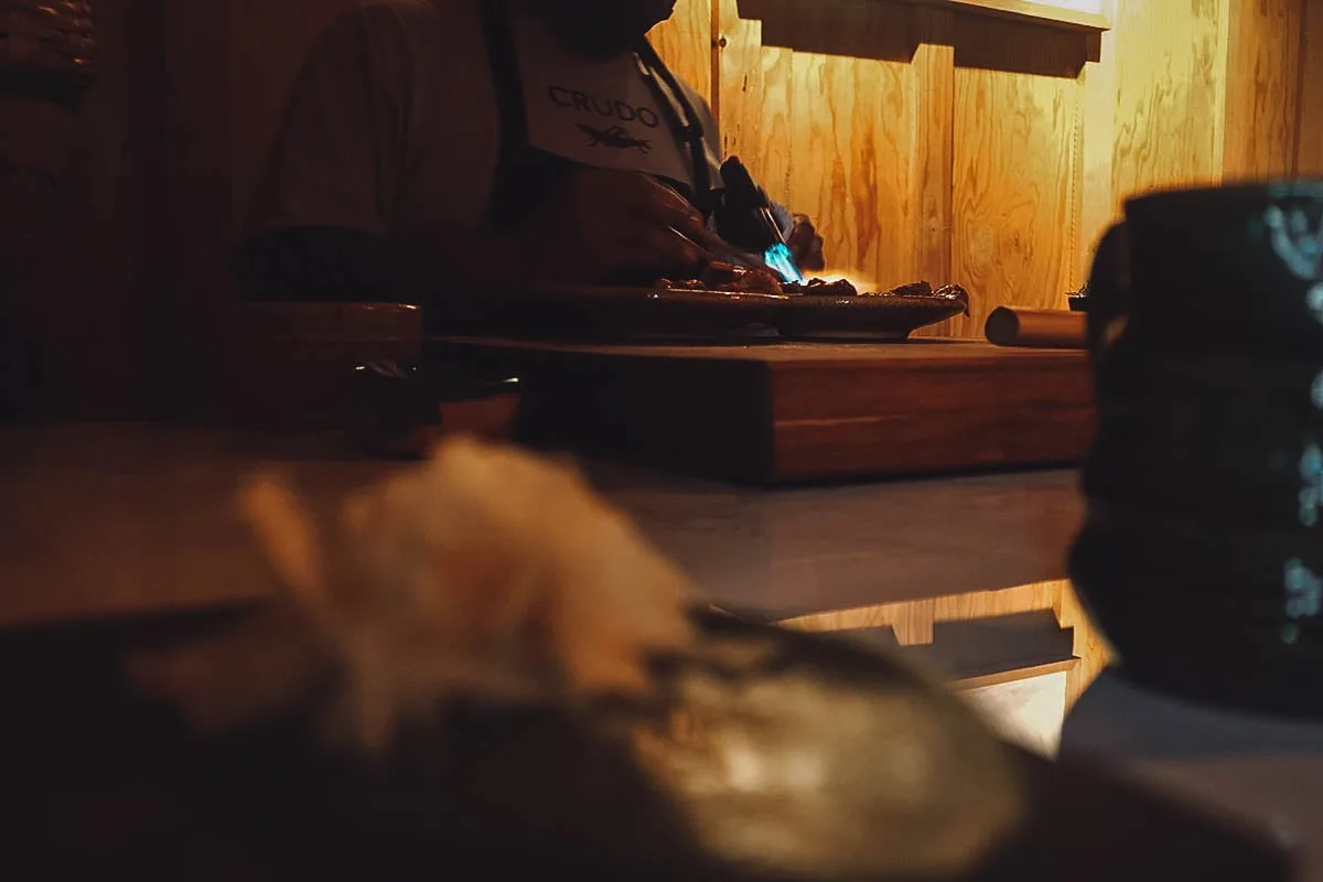 Chef torching seabass at Crudo restaurant in Oaxaca, Mexico