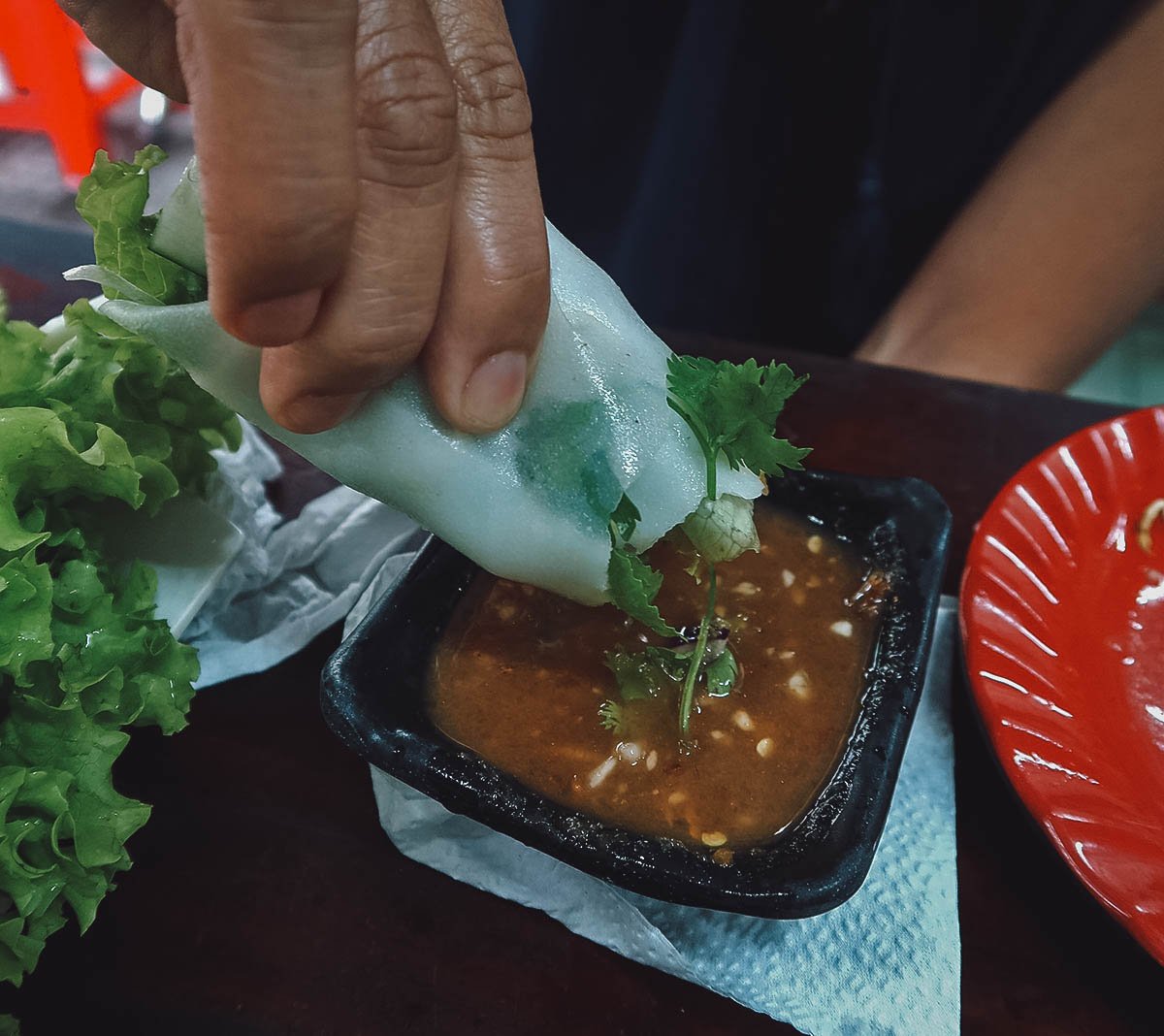 Dipping banh trang thit heo in the sauce