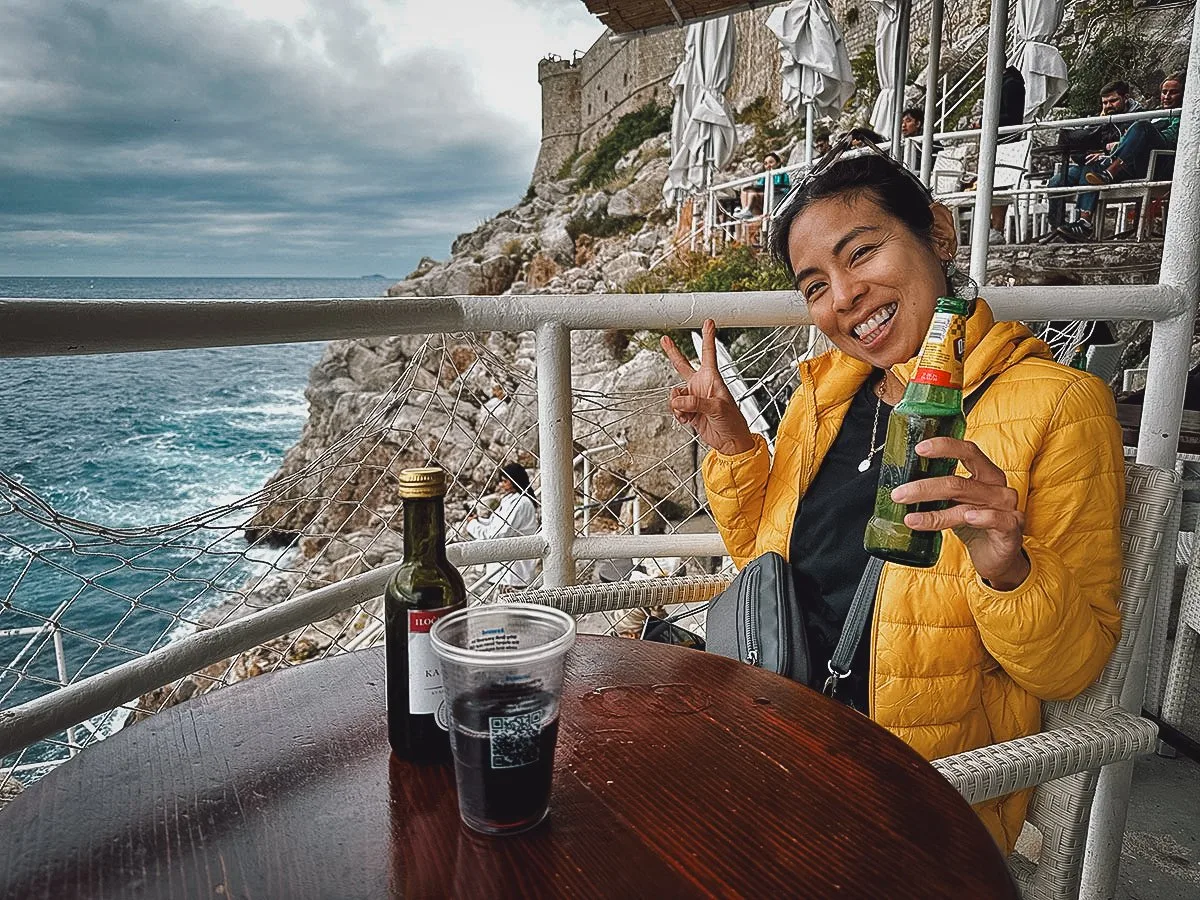 Woman enjoying beer at Buza Bar in Dubrovnik