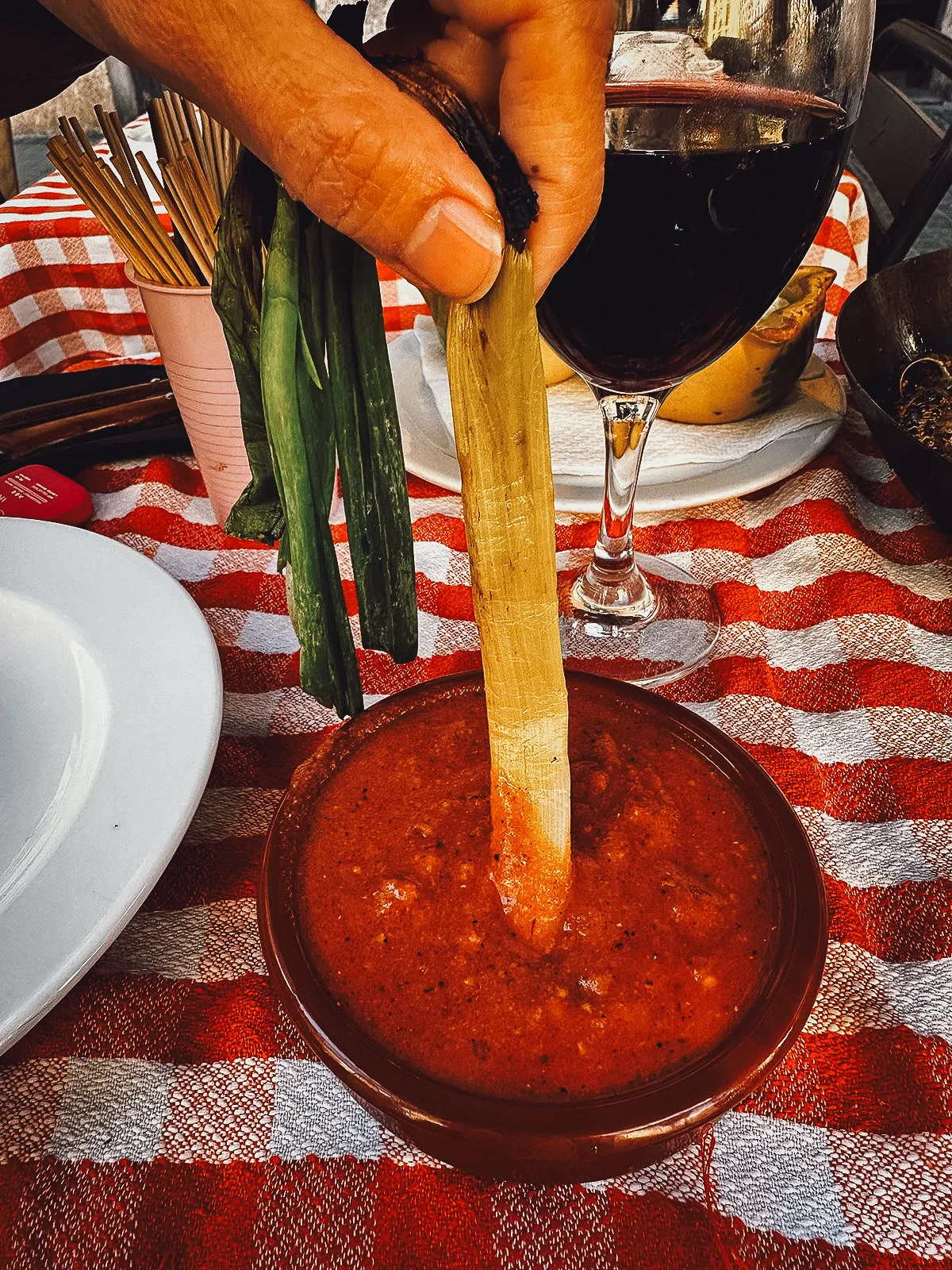 Dipping a calcot in sauce at a restaurant in Barcelona