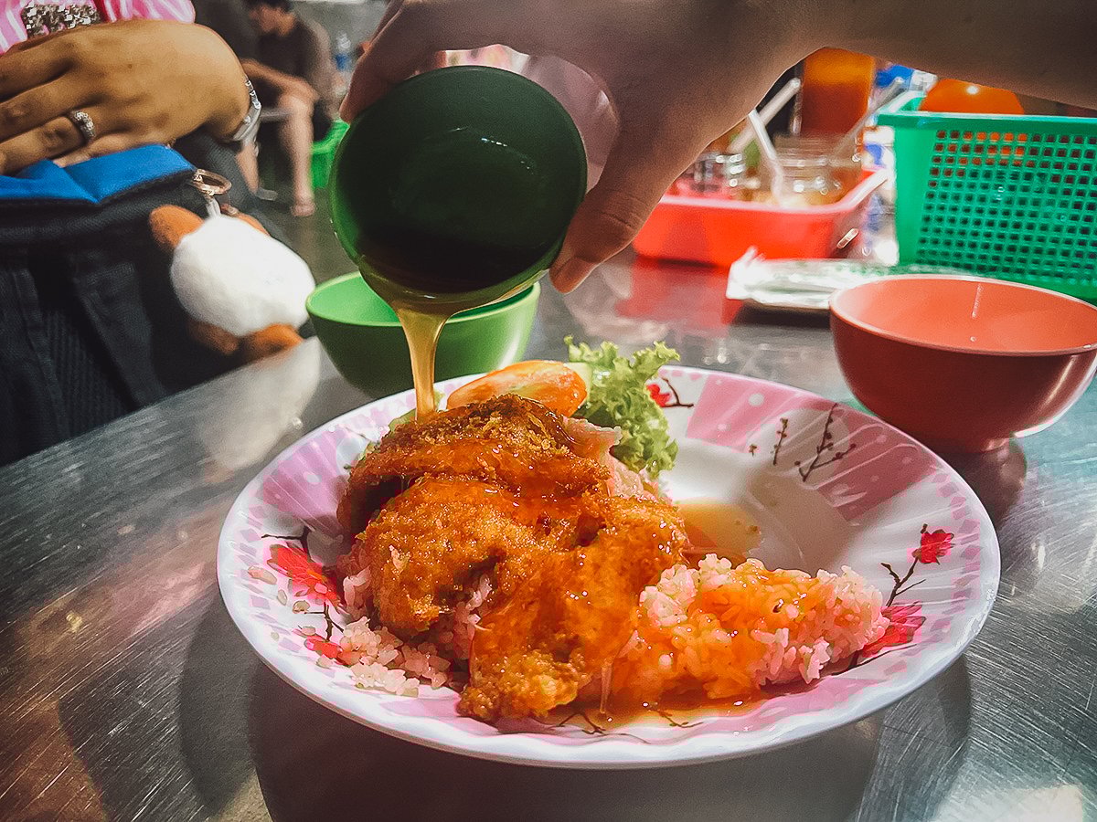 Pouring sauce onto fried chicken