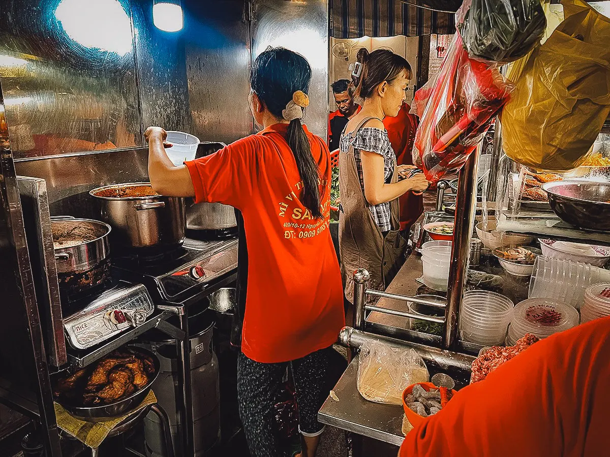 Food stall workers preparing Vietnamese dishes