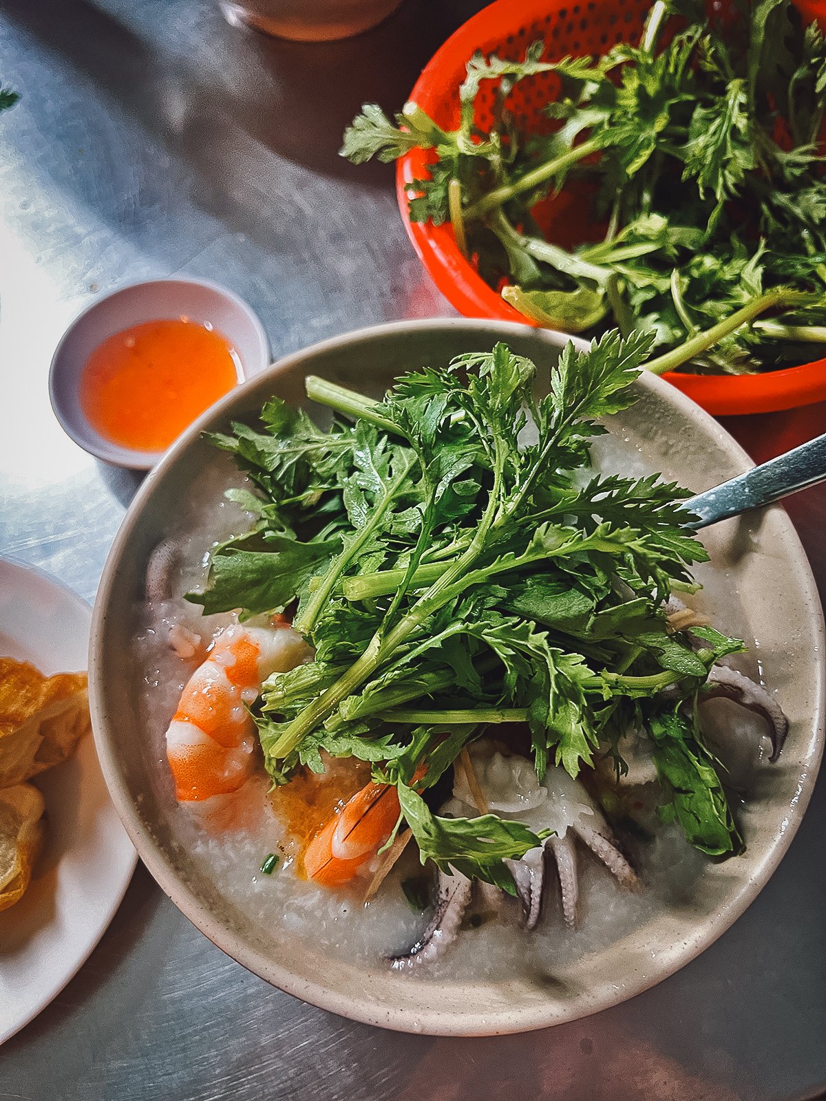 Hidden Eateries in Saigon's Chinatown Seafood porridge topped with garland chrysanthemum