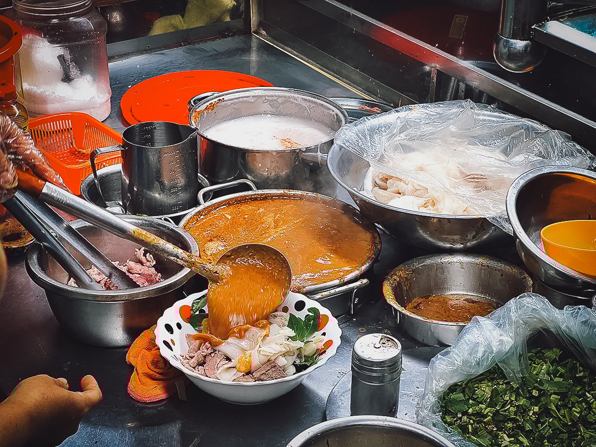 Ladling curry sauce into a bowl
