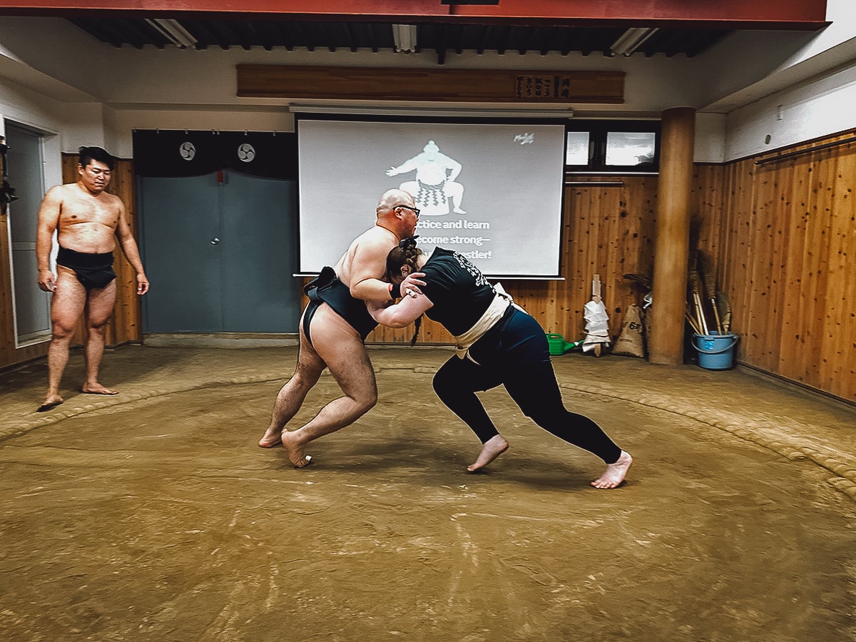 Sumo Experience in Tokyo Retired Sumo wrestler wrestling with a tourist