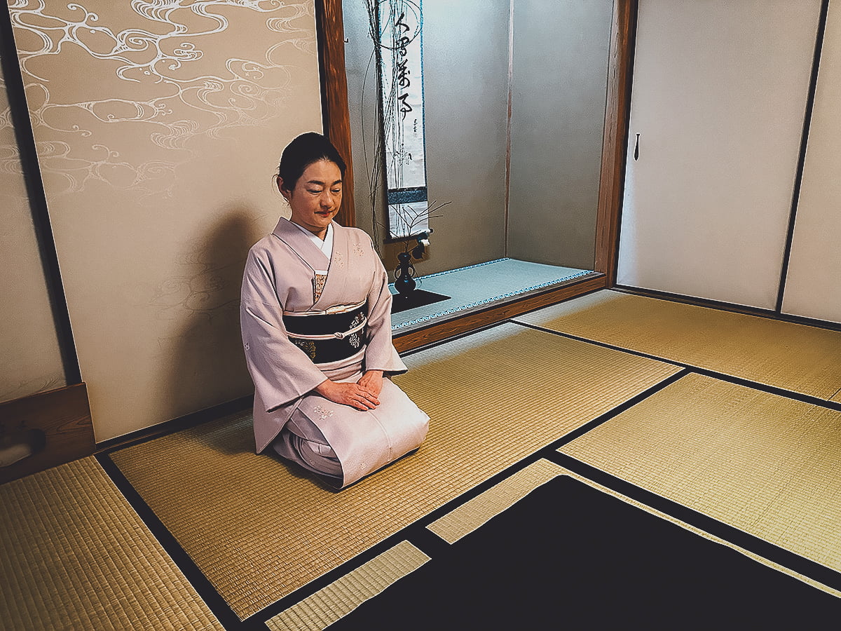 Japanese woman in a kimono seated in a tea room